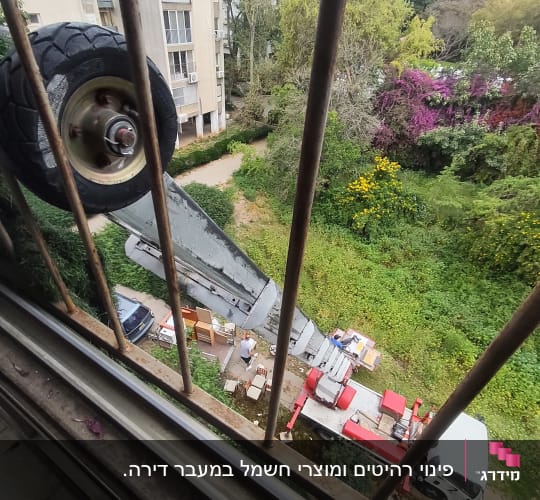 מנוף מעביר רהיטים מחוץ לבניין